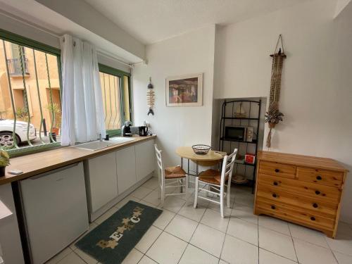 une cuisine avec un comptoir, une table et des chaises dans l'établissement Studio plein coeur d'Argeles sur Mer, à Argelès-sur-Mer