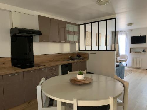 a kitchen with a white table and a dining room at LOGIS HOTELS - Hôtel et Restaurant L'Océana in Lanton