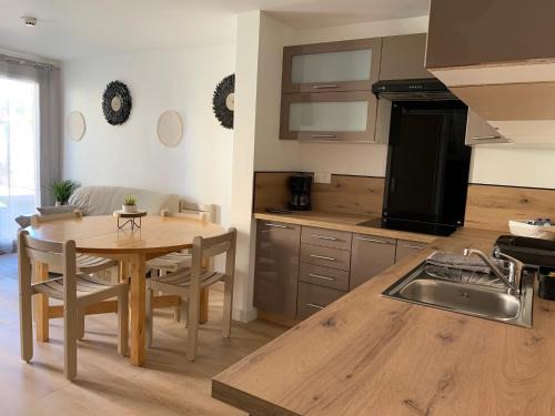 a kitchen with a wooden table and a dining room at LOGIS HOTELS - Hôtel et Restaurant L'Océana in Lanton