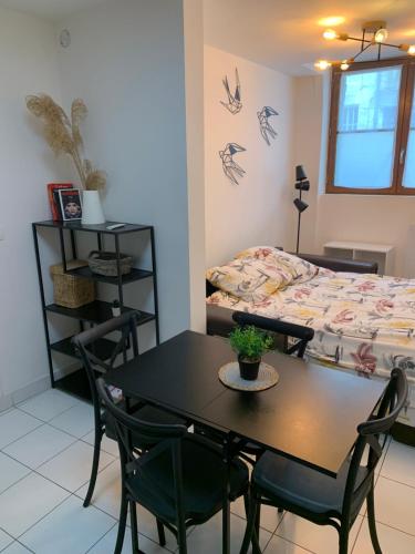 - une salle à manger avec une table, des chaises et un lit dans l'établissement L'escapade céleste, à Orléans