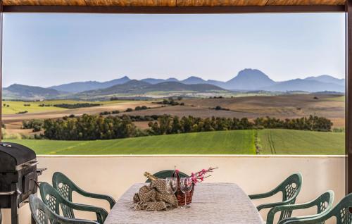 a table with chairs and a view of a field at Vistas De La Sierra in Arcos de la Frontera