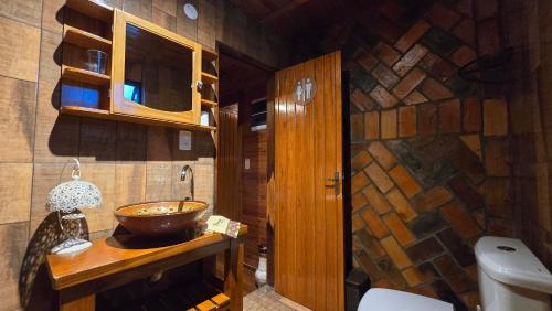a bathroom with a wooden sink and a toilet at Mahanaim Casa De Campo in Caaguazú
