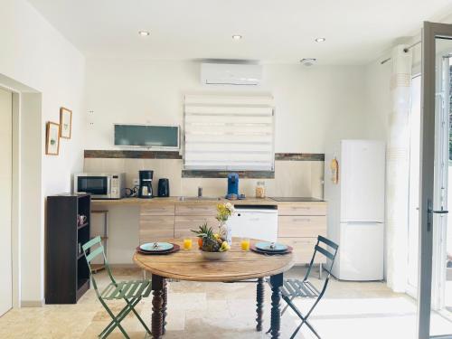 - une cuisine avec une table et des chaises en bois dans l'établissement Beau 2 pièces emplacement n 1 proche de la mer, à Fréjus