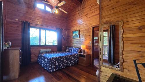 a bedroom with a bed in a wooden cabin at Mahanaim Casa De Campo in Caaguazú