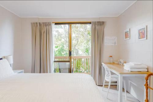 a bedroom with a bed and a desk and a window at Joe & Mary's Cosy homestay room in Auckland