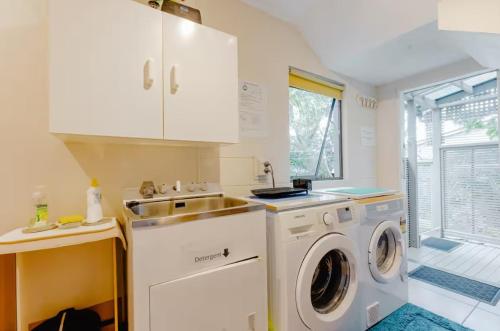 a kitchen with a washing machine and a sink at Joe & Mary's Cosy homestay room in Auckland