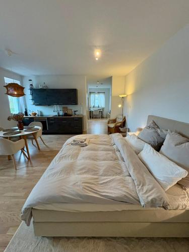 a large bed in a bedroom with a living room at Tamm CityHub Zentral, Komfortabel, Tiefgarage in Tamm