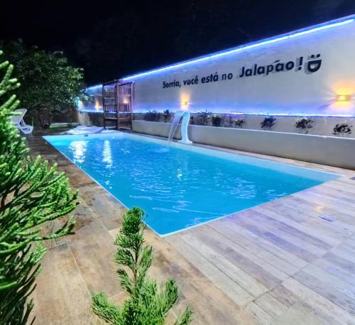 Una piscina frente a un edificio por la noche. en Pousada Ame Jalapão, en Mateiros