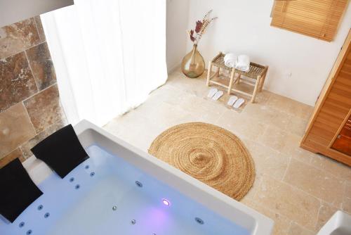 a bathroom with a large tub in a room at Villa l'Insolente Spa Sauna Chambre 50 nuances de Grey in Lembras