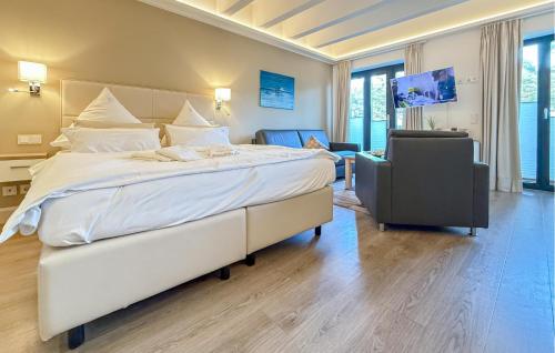 ein Schlafzimmer mit einem großen weißen Bett und einem Stuhl in der Unterkunft Baltic in Binz