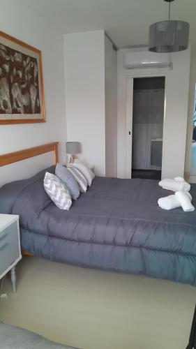 a bedroom with a blue bed with pillows on it at Blue House in San Nicolás de los Arroyos
