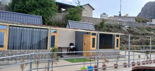 a house with a person standing outside of it at Dhanolti Village Resort Dhanaulti in Dhanaulti