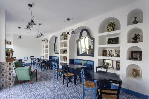 una sala da pranzo con tavoli e sedie e una parete con specchi di Hotel Mignon Meublè a Sorrento
