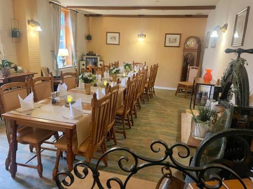 a dining room with a long table and chairs at Harzhotel Warnstedter Krug in Thale