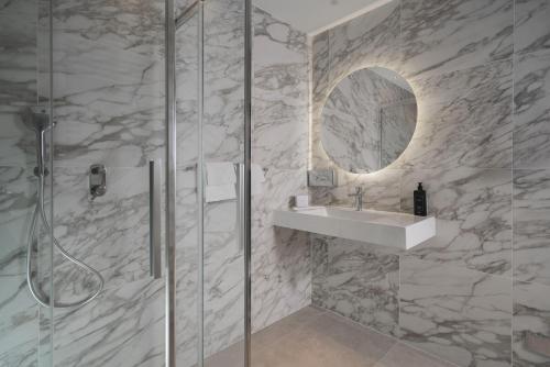 a bathroom with a shower and a sink and a mirror at Doria Park Hotel in Lerici