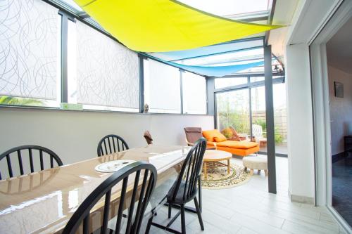 une salle à manger avec une table, des chaises et des fenêtres dans l'établissement Milin Avel I 6 personnes & plage, à Crozon