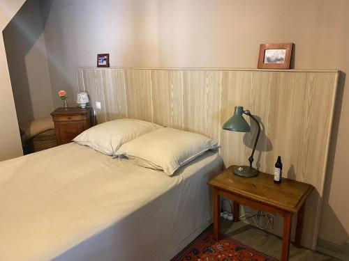 une chambre avec un lit avec une lampe sur une table dans l'établissement Charmant appartement au calme avec grand jardin au pied des remparts, à Brignoles