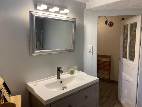 une salle de bain avec un lavabo blanc et un miroir dans l'établissement Charmant appartement au calme avec grand jardin au pied des remparts, à Brignoles