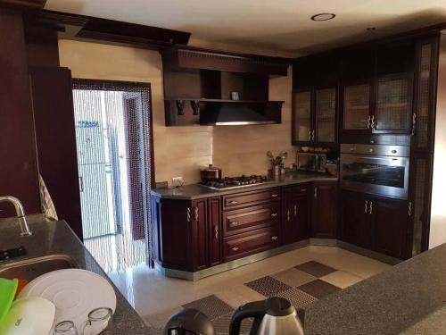 een keuken met houten kasten en een kookplaat met oven bij القاهرة العبور الحي التاسع in Obour