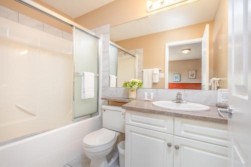 une salle de bain avec un lavabo, des toilettes et un miroir dans l'établissement Paradise Canyon Golf Resort - Luxury Condo U403, à Lethbridge