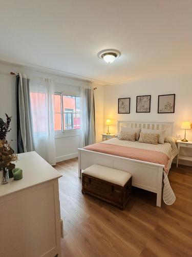a white bedroom with a large bed and a window at La Casita de las Vistas in A Guarda