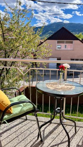 a table with a vase of flowers on a patio at Guest House Bosnian House in Sarajevo