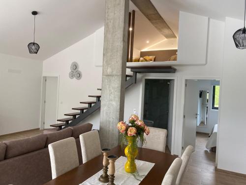 a living room with a table with a vase of flowers at Quinta da Barrosa - Arouca in Arouca