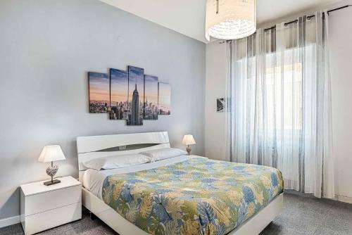 a white bedroom with a bed and a large window at Souvenir, Terre Marine in La Spezia