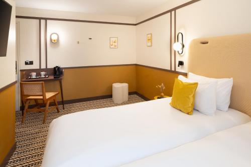 a hotel room with a large bed and a desk at Best Western Plus Au Grand Saint Jean in Beaune