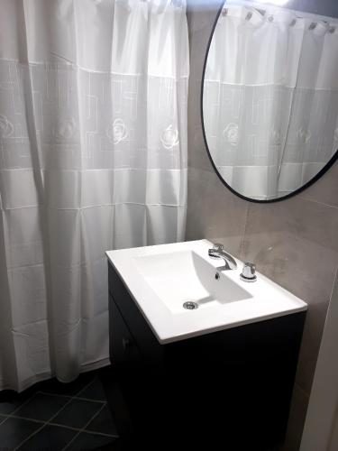 a bathroom with a sink and a mirror at Blue House in San Nicolás de los Arroyos