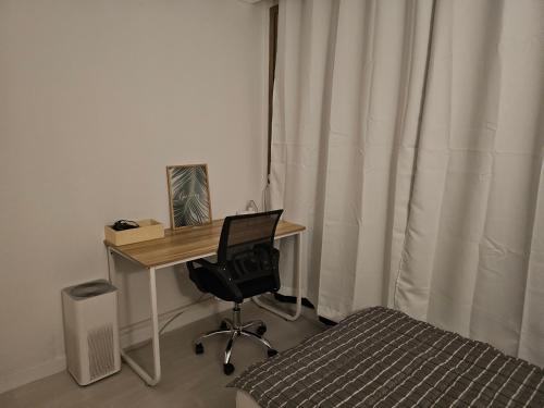 a bedroom with a desk with a computer and a bed at Stay JAYU in Daejeon