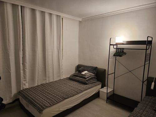 a small bedroom with a bed and a window at Stay JAYU in Daejeon