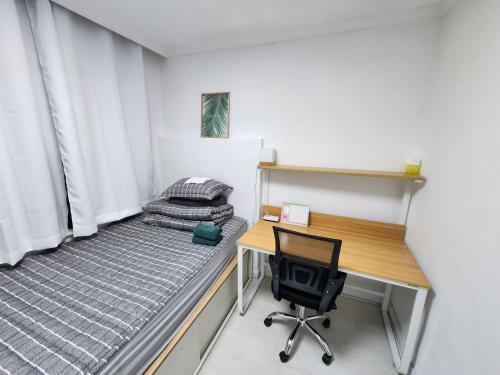 a bedroom with a desk and a bed and a chair at Stay JAYU in Daejeon