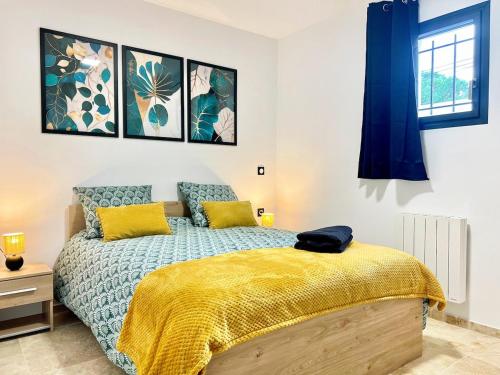 - une chambre dotée d'un lit avec des draps jaunes et bleus dans l'établissement Les Jasmins - 2 Appartements cosy, CLIM, Terrasse, 5 lits, 2 SDB, 8 personnes, à Fos-sur-Mer