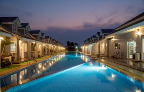 a swimming pool in a resort at night at The Memory Luxury Resort in Haad Chao Samran
