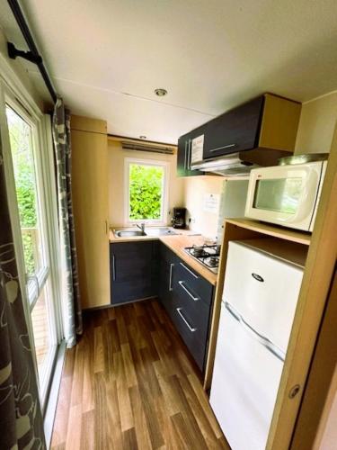 une petite cuisine avec un évier et un réfrigérateur dans l'établissement Camping paradis de la plage, à Saint-Cirq-Lapopie