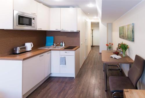a small kitchen with white cabinets and a table at Your city apartment. in Tallinn