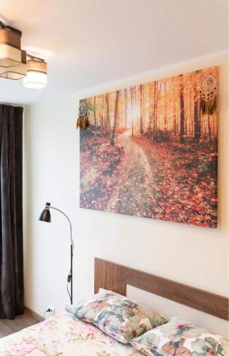 a bedroom with a painting hanging on the wall at Your city apartment. in Tallinn