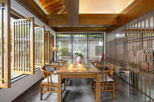 a dining room with a wooden table and chairs at 南京又见江南民宿 in Nanjing