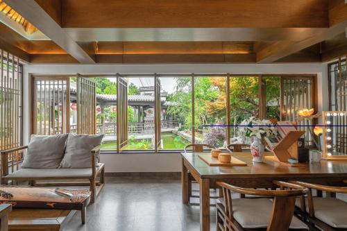 a living room with a table and a large window at 南京又见江南民宿 in Nanjing