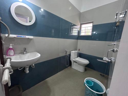 a bathroom with a sink and a toilet and a mirror at Anya Retreats Nature Homestay in Kushālnagar