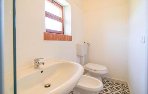 a white bathroom with a toilet and a sink at Dimora Di Famiglia in Belmonte Mezzagno