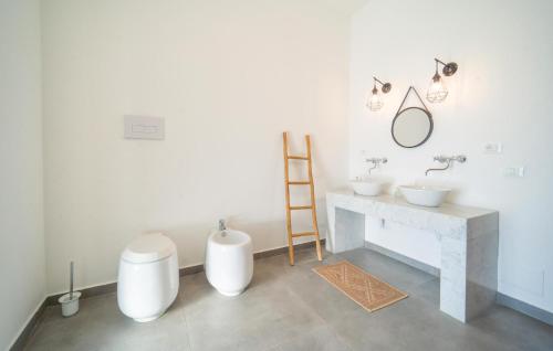 a white bathroom with two sinks and a mirror at Dimora Di Famiglia in Belmonte Mezzagno