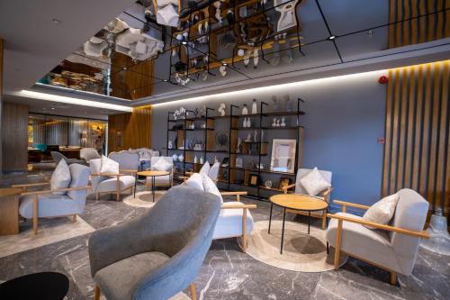 a waiting room with chairs and tables and shelves at Park Inn by Radisson Najran in Najran