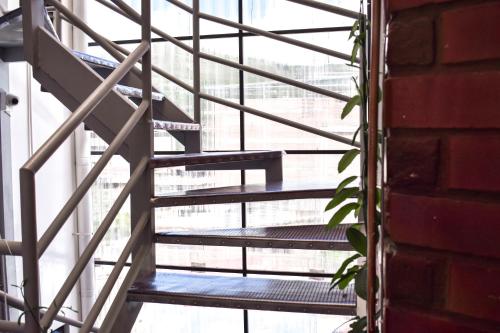 a metal staircase in a room with a brick wall at Tony Montaña B&B in Huaraz
