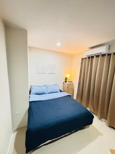 Un dormitorio con una cama azul en una habitación. en Zebs cozy cove, en Cebú
