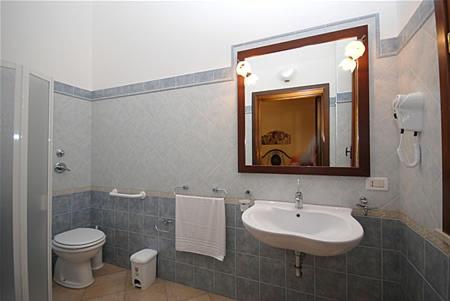 a bathroom with a sink and a toilet and a mirror at Kimos in San Vito lo Capo