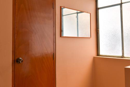 an orange room with a door and a window at Tony Montaña B&B in Huaraz