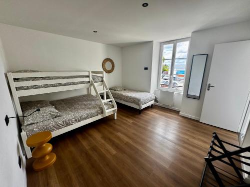 une chambre avec deux lits superposés et un plancher en bois dans l'établissement Chambre dans maison cosy, à Château-Gontier