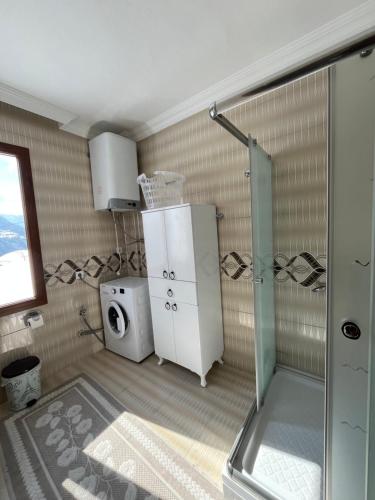 ein Badezimmer mit Dusche und Waschmaschine in der Unterkunft Defne Apart in Çamlıhemşin